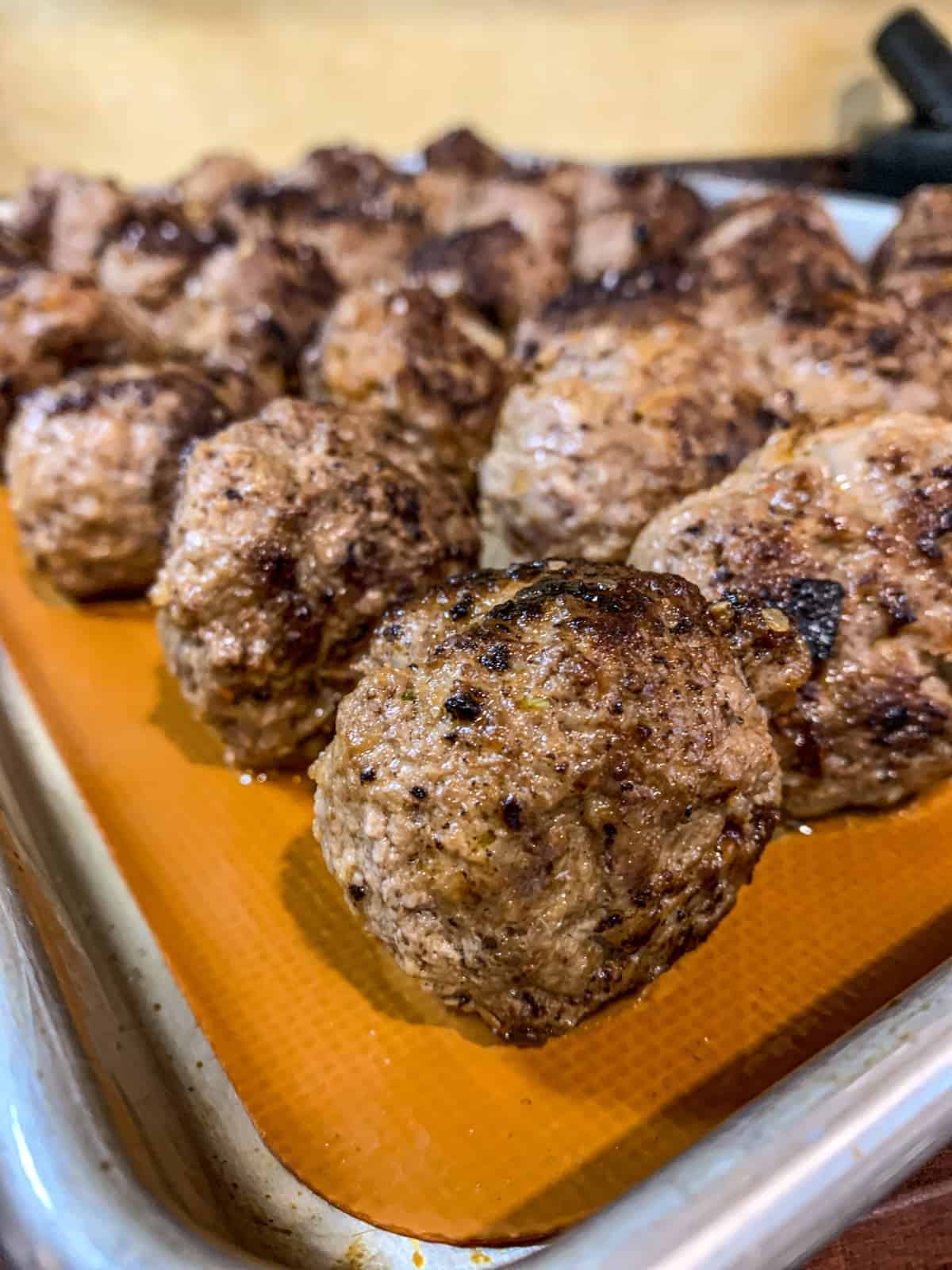 Baked homemade meatballs on a sheet pan